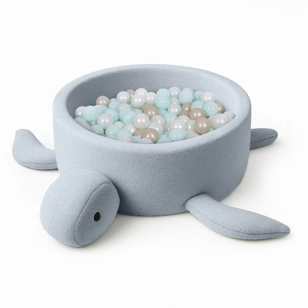 2. Turtle-shaped baby ball pit in dusty ice blue boucle fabric filled with pastel-colored balls, shown on a white background
