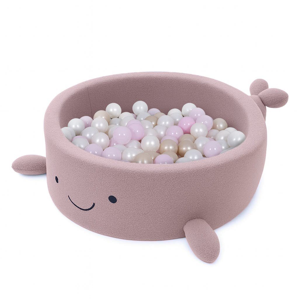 2. Whale-shaped baby ball pit in raspberry glaze pink boucle filled with pastel-colored balls