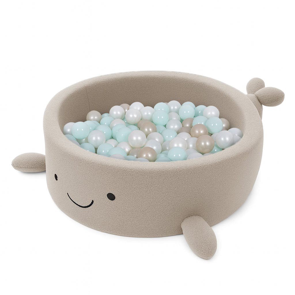 2. Beige whale-shaped foam baby ball pit filled with pastel-colored balls, featuring soft boucle finish and smiling face