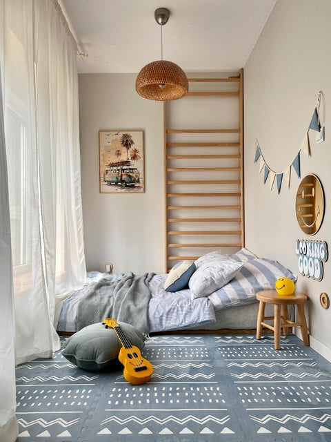 3. Blue OLYA KIDS Boho puzzle playmat in cozy bedroom with bed, pillows, and decorative items