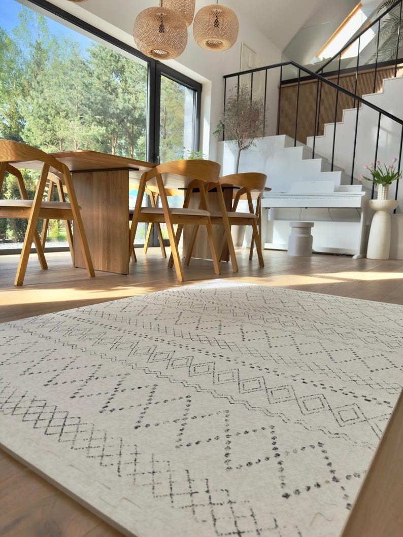 3. Close-up of ivory and black boho playmat in dining area with wooden furniture and large windows