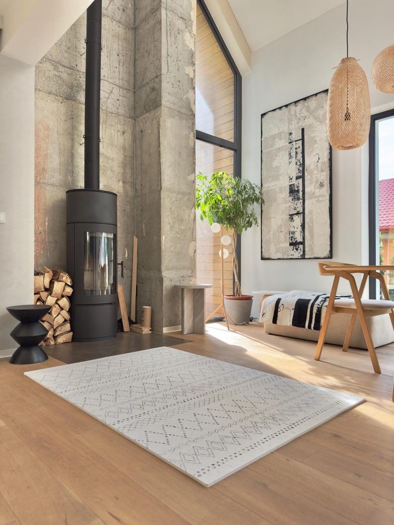 2. Ivory and black boho playmat in modern living room with large windows and wood accents