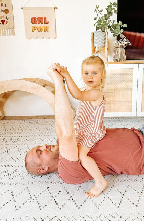 1. Man and child playing on ivory and black boho playmat in bright room with decor