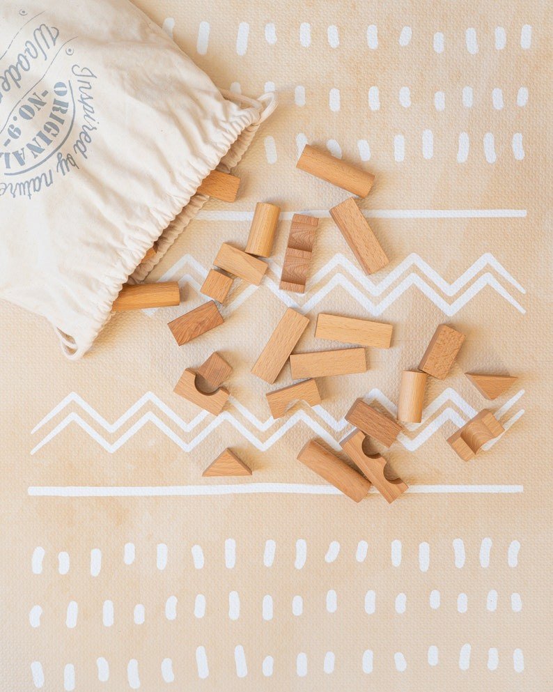 3. Close-up of wooden blocks on OLYA KIDS Boho sand puzzle playmat with fabric bag