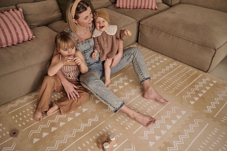 1. Mother with two children sitting on OLYA KIDS Boho sand puzzle playmat in a comfortable living room