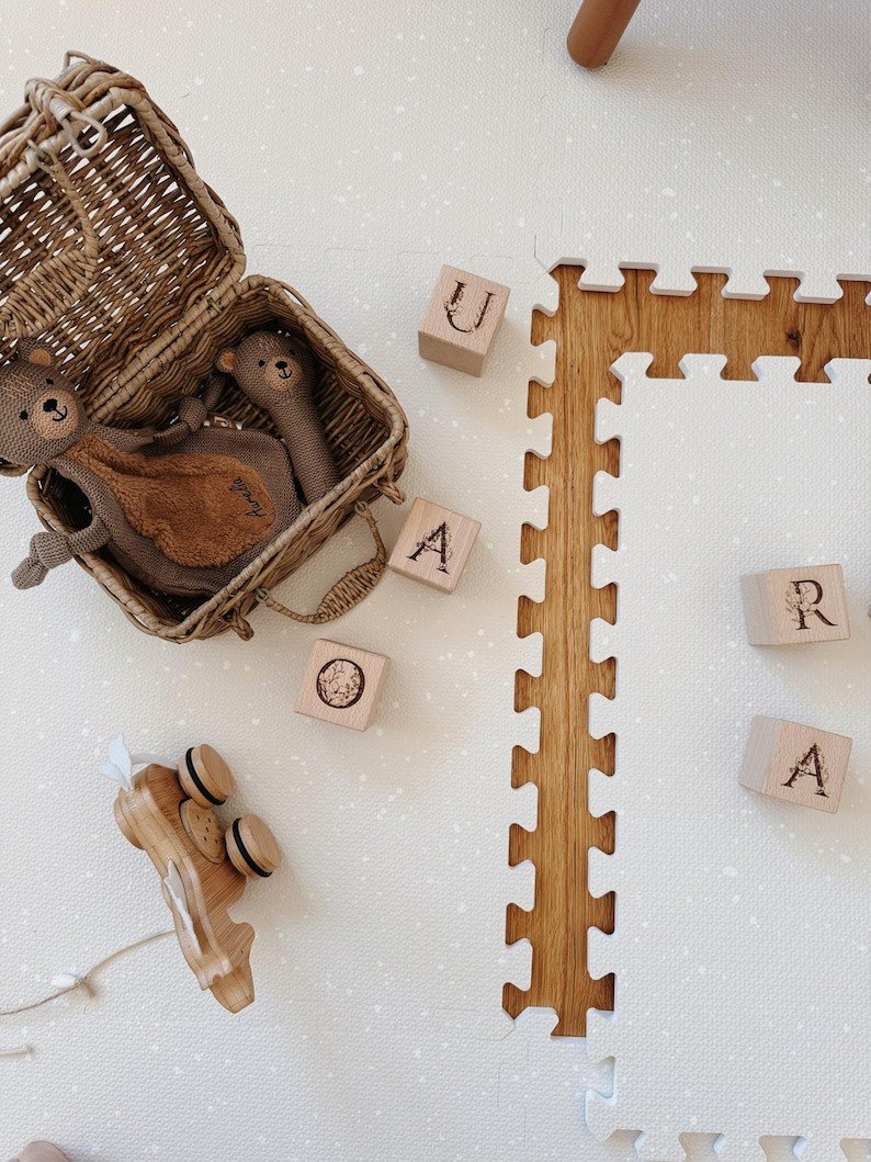 3. Close-up of OLYA KIDS cashmere spots playmat with wooden blocks and wicker basket on wooden floor
