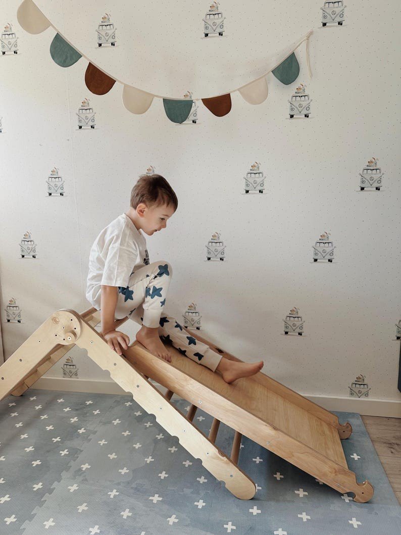 1. Child playing on wooden slide over OLYA KIDS Cross Azure foam puzzle playmat in decorated room