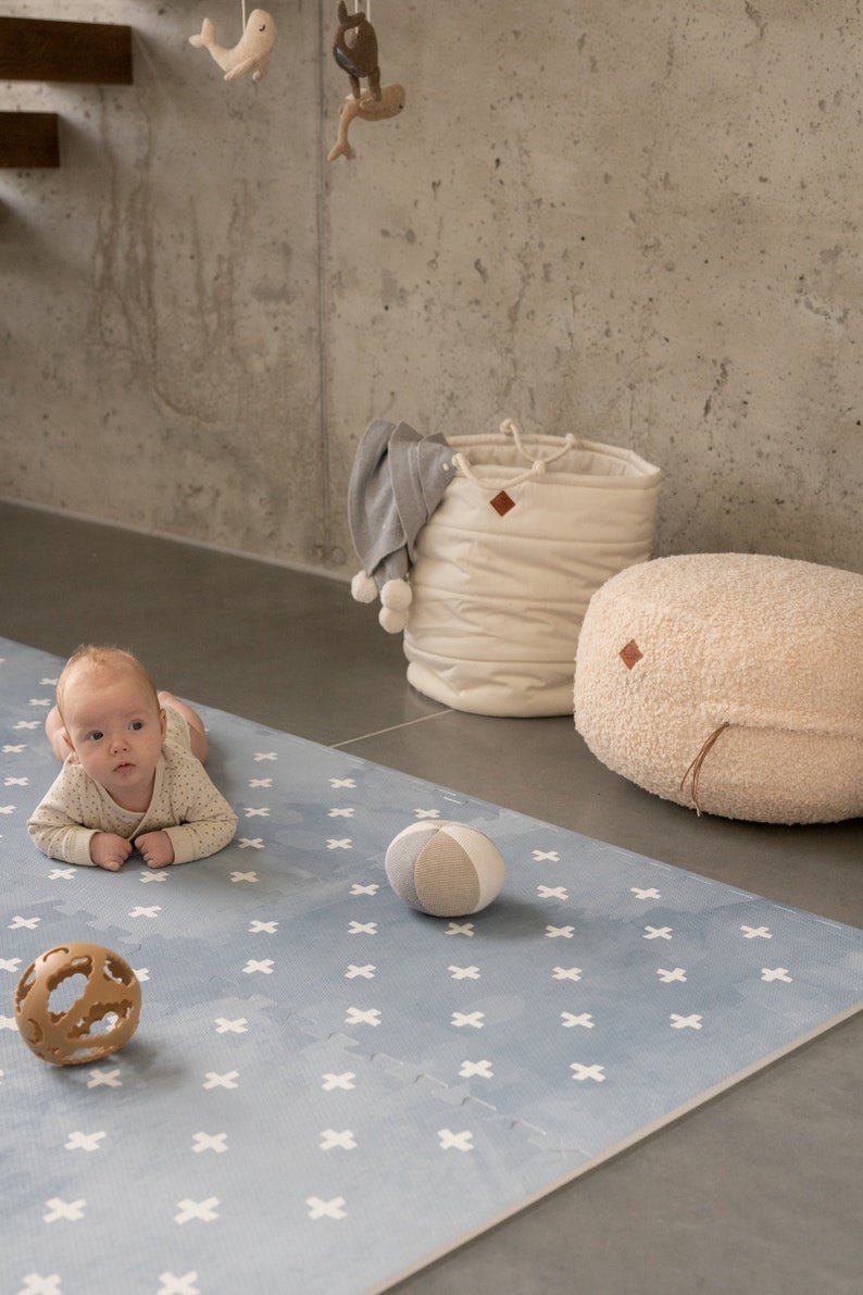 1. Baby on tummy on OLYA KIDS Cross Azure foam puzzle playmat with toys in cozy room