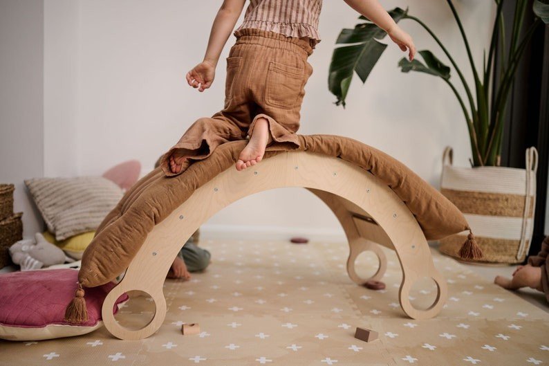 5. Child playing on wooden arch over OLYA KIDS Cross sand foam puzzle playmat in playroom