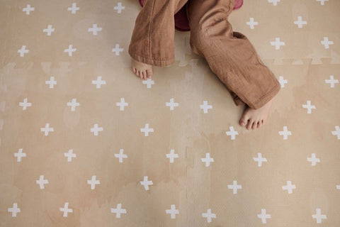 4. Close-up of child's feet on OLYA KIDS Cross sand foam puzzle playmat showing texture