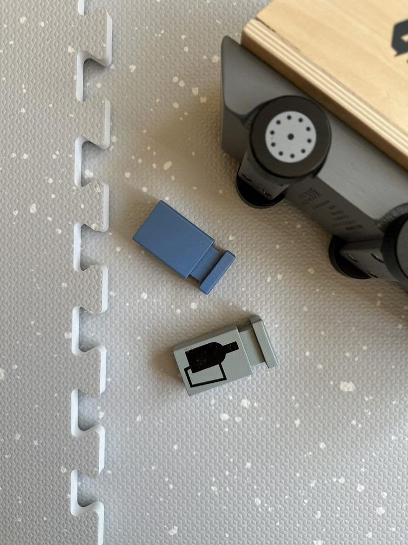 3. Close-up of foam puzzle playmat in dove color with toy recycling truck and small blocks, showing texture and design