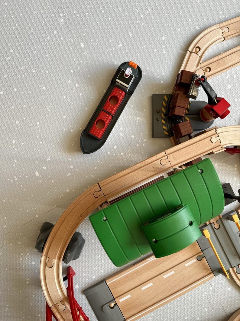 4. Foam puzzle playmat in dove color with toy boat and train tracks, highlighting play area details