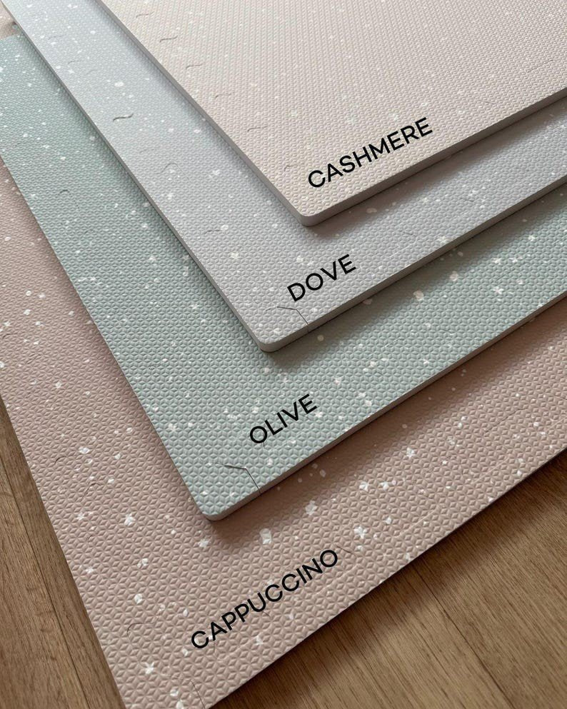 3. Close-up of stacked foam puzzle playmats in cappuccino, olive, dove, and cashmere colors on wooden floor