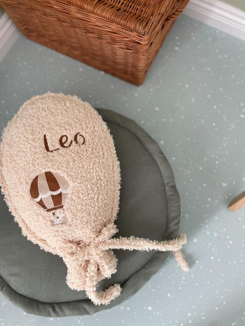 2. Close-up of personalized plush toy on olive foam puzzle playmat with wicker basket in background