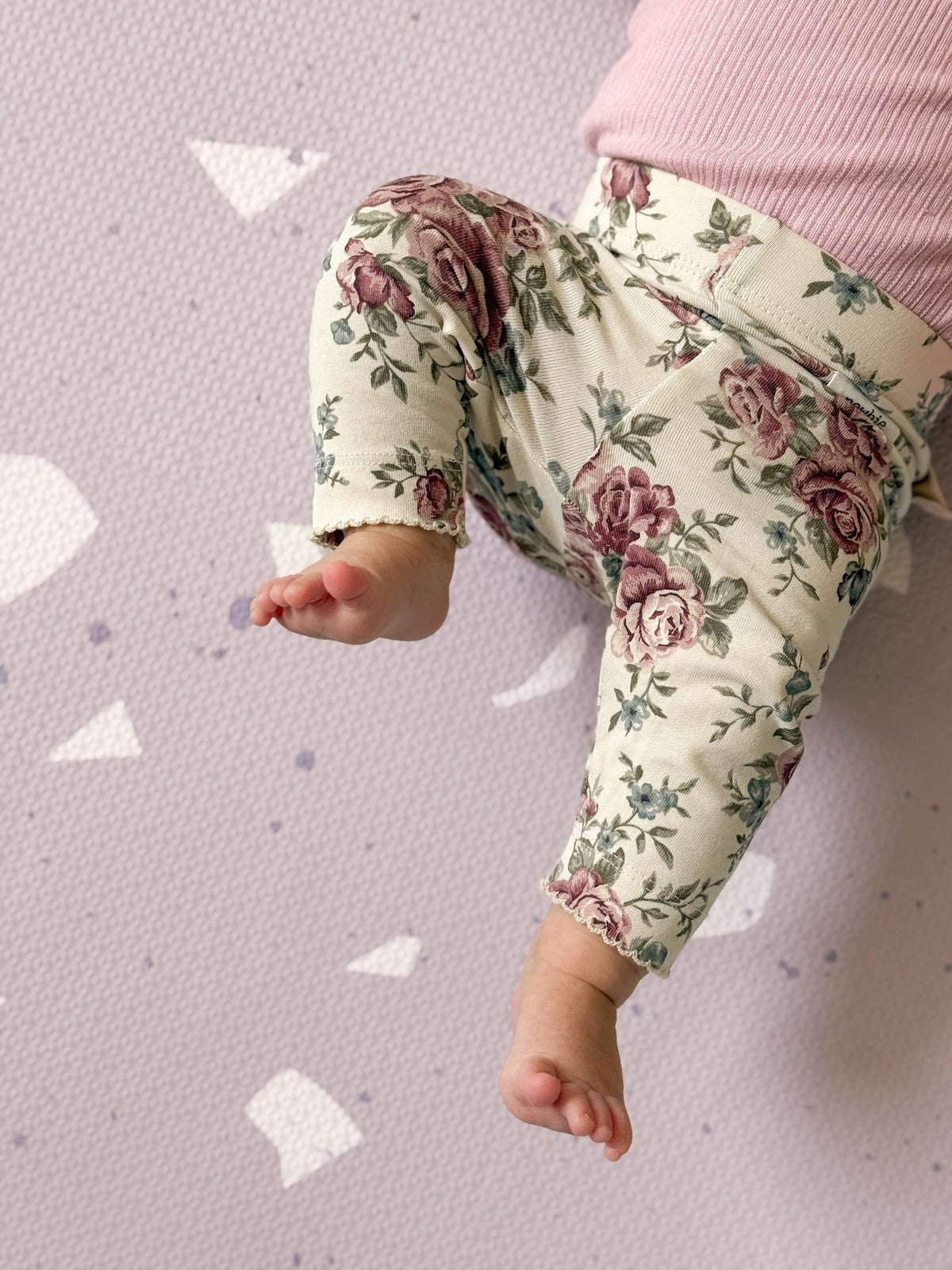 8. Close-up of baby's floral pants on lavender terrazzo playmat