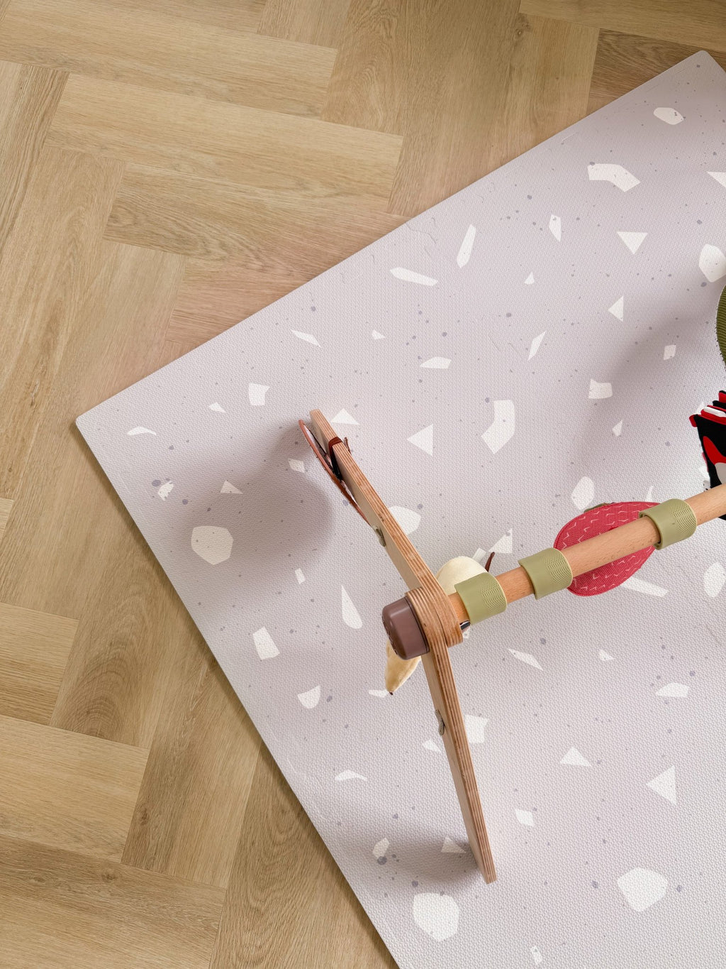 9. Wooden play gym on lavender terrazzo playmat with parquet flooring