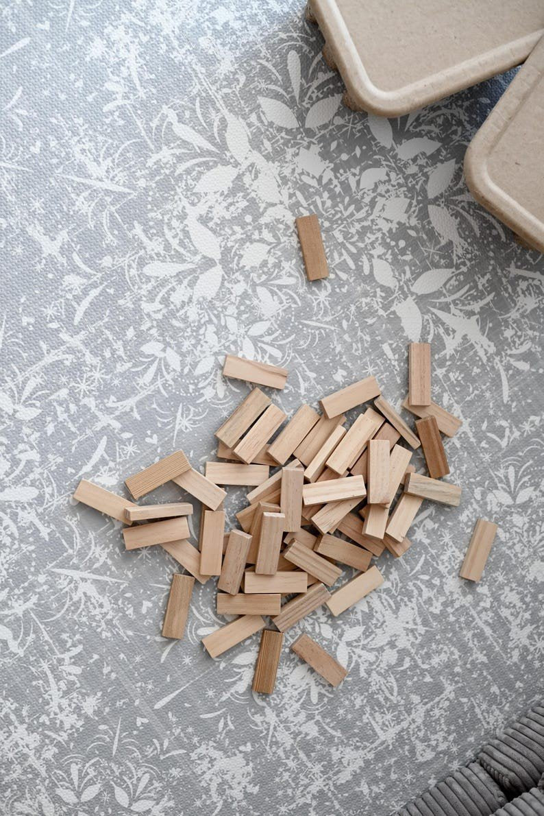 5. Wooden blocks scattered on OLYA KIDS vintage grey foam puzzle playmat highlighting detailed floral design