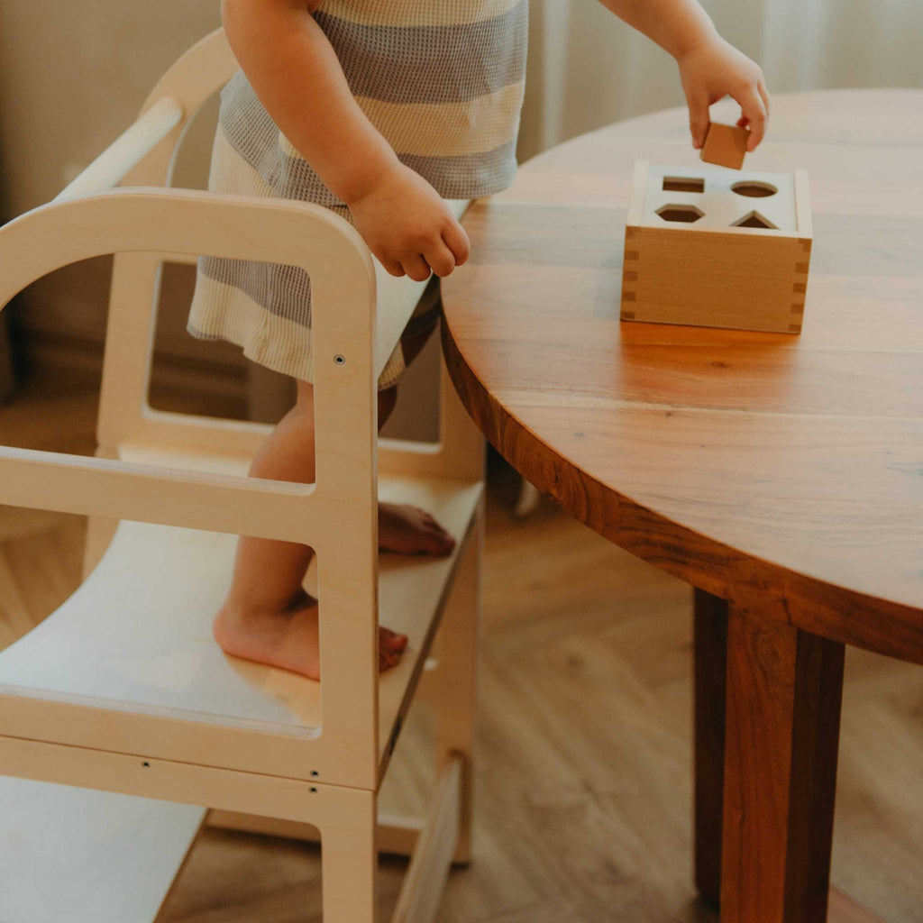12. Close-up of child playing with toy on natural birch kitchen tower