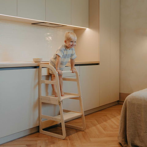 1. Child using natural birch kitchen tower at counter in modern kitchen