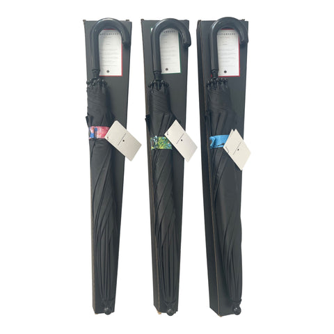 2. Three packaged children's umbrellas with black covers and colorful forest-themed bands, featuring curved handles and tags, displayed upright