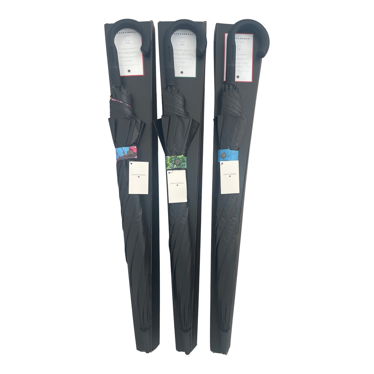 2. Three packaged large umbrellas with black covers and visible forest design tags, highlighting brand HAPPYSWEEDS
