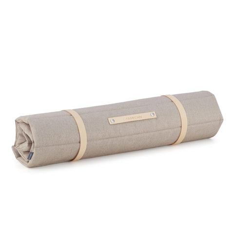 2. Rolled-up Fosser travel mat in beige with leather straps and Labbvenn logo on a white background