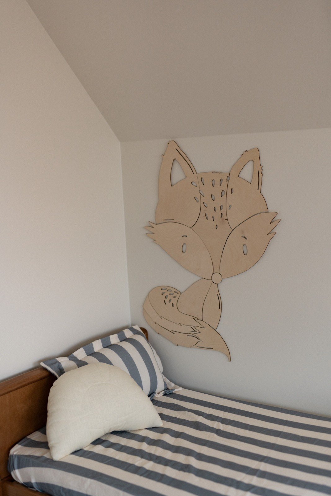 4. Fox wooden wall decoration in children's room with striped bedding and pillow