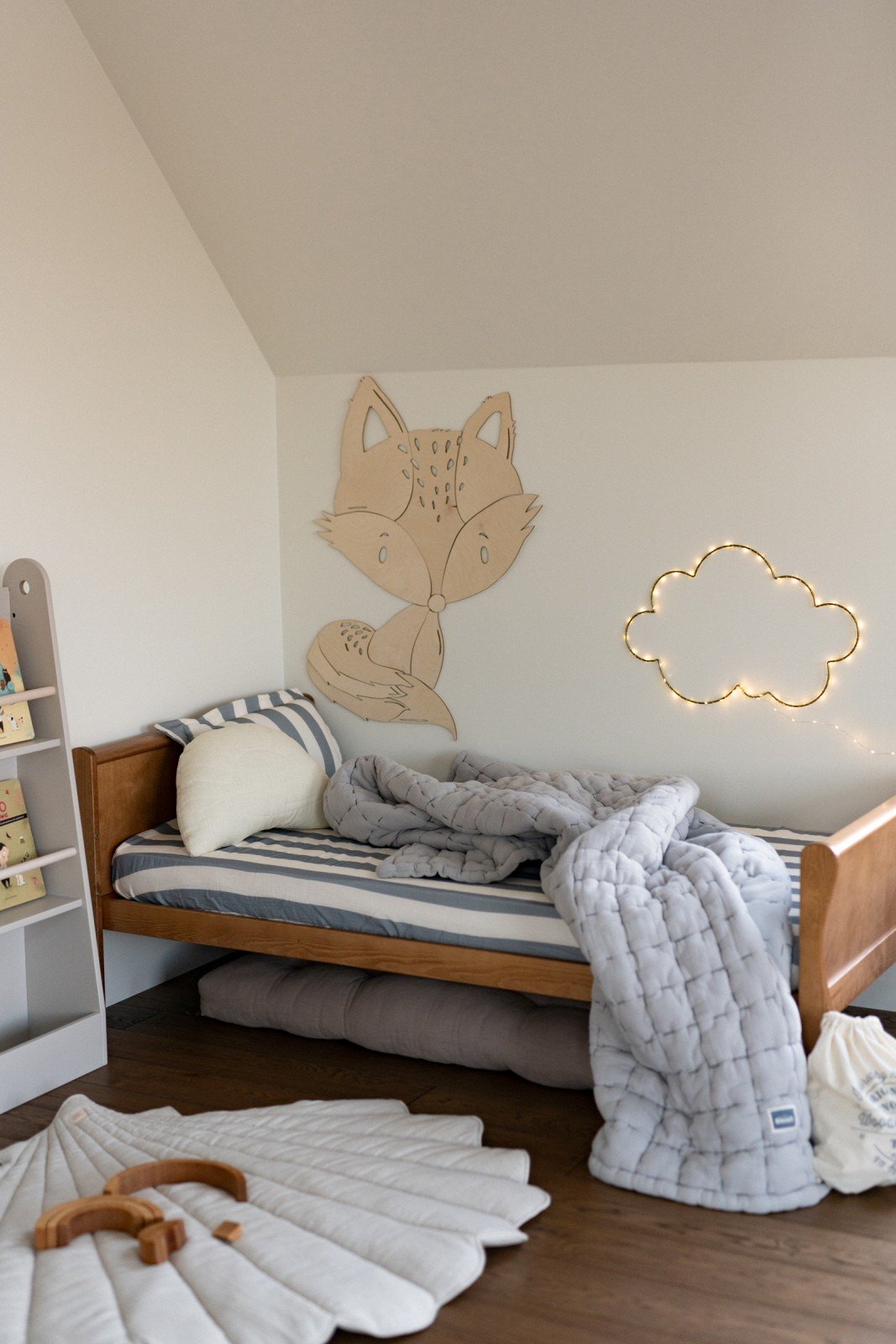 6. Fox wooden wall decoration in cozy children's room with cloud light and bedding
