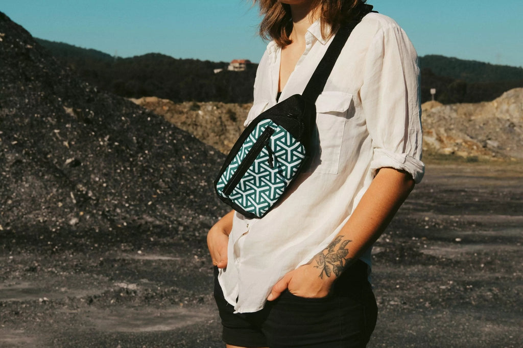 1. Woman wearing Drinbags BEANS waist bag with geometric pattern, styled crossbody in outdoor setting