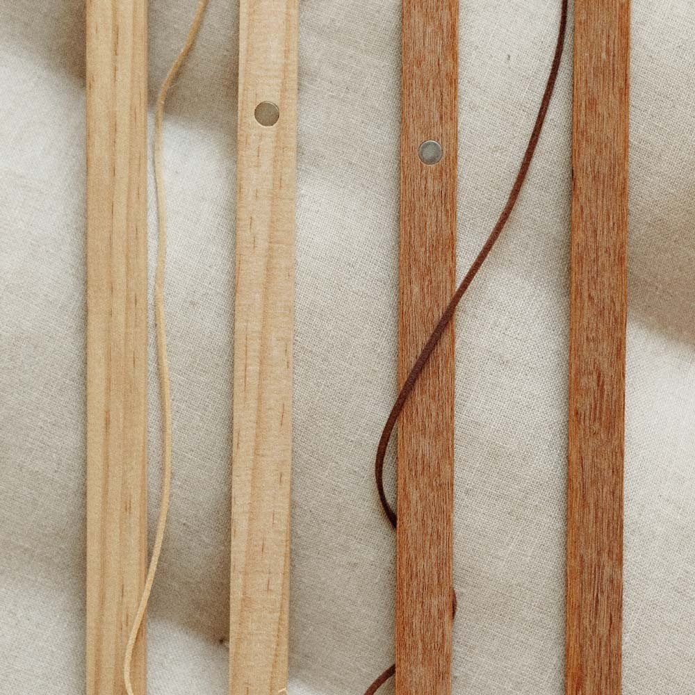 5. Terra Mamma oak wood frame pieces on a beige fabric background highlighting magnetic design