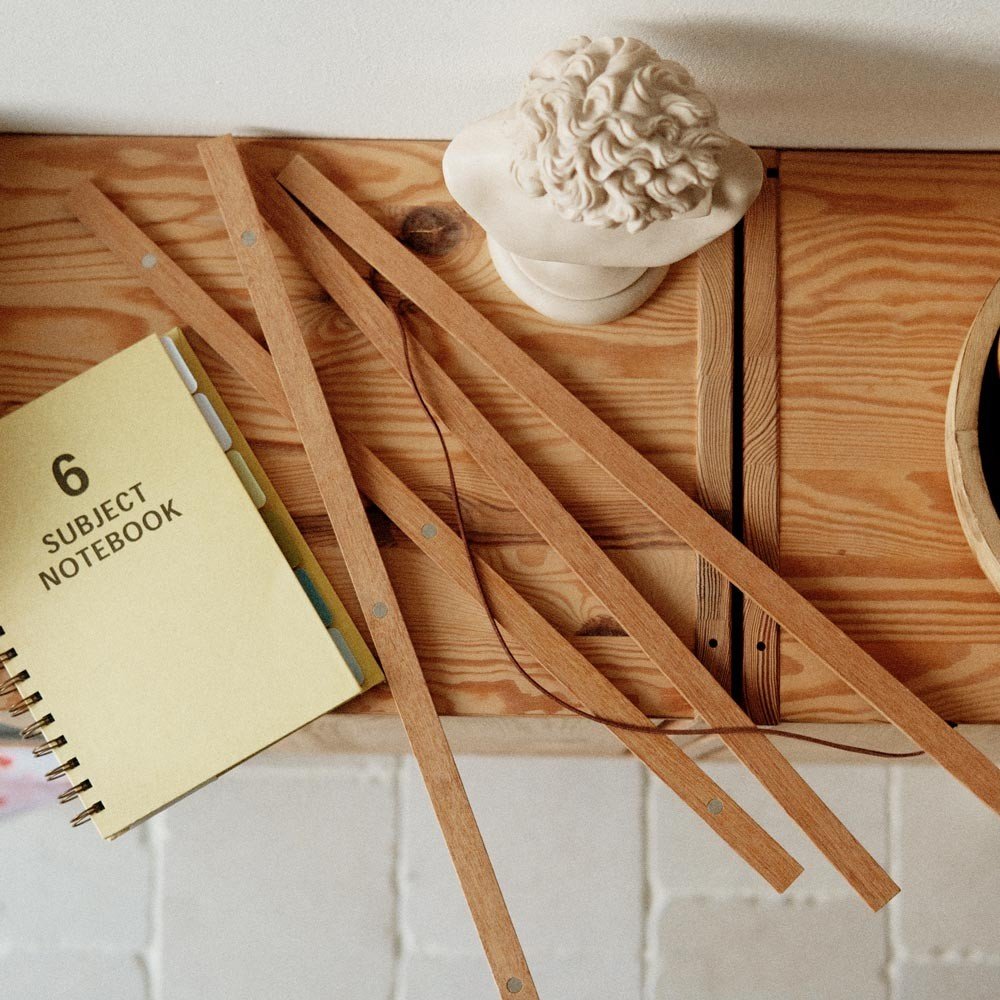 4. Terra Mamma oak wood frame pieces on a wooden table with a notebook and decorative bust