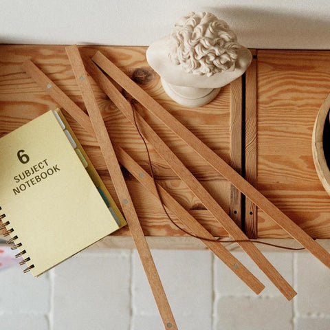 4. Terra Mamma oak wood frame pieces on a wooden table with a notebook and decorative bust