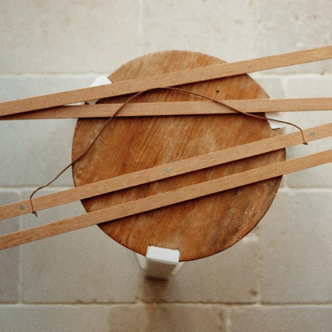 1. Terra Mamma oak wood magnetic frame pieces on a round wooden stool, showcasing natural grain and minimalist design