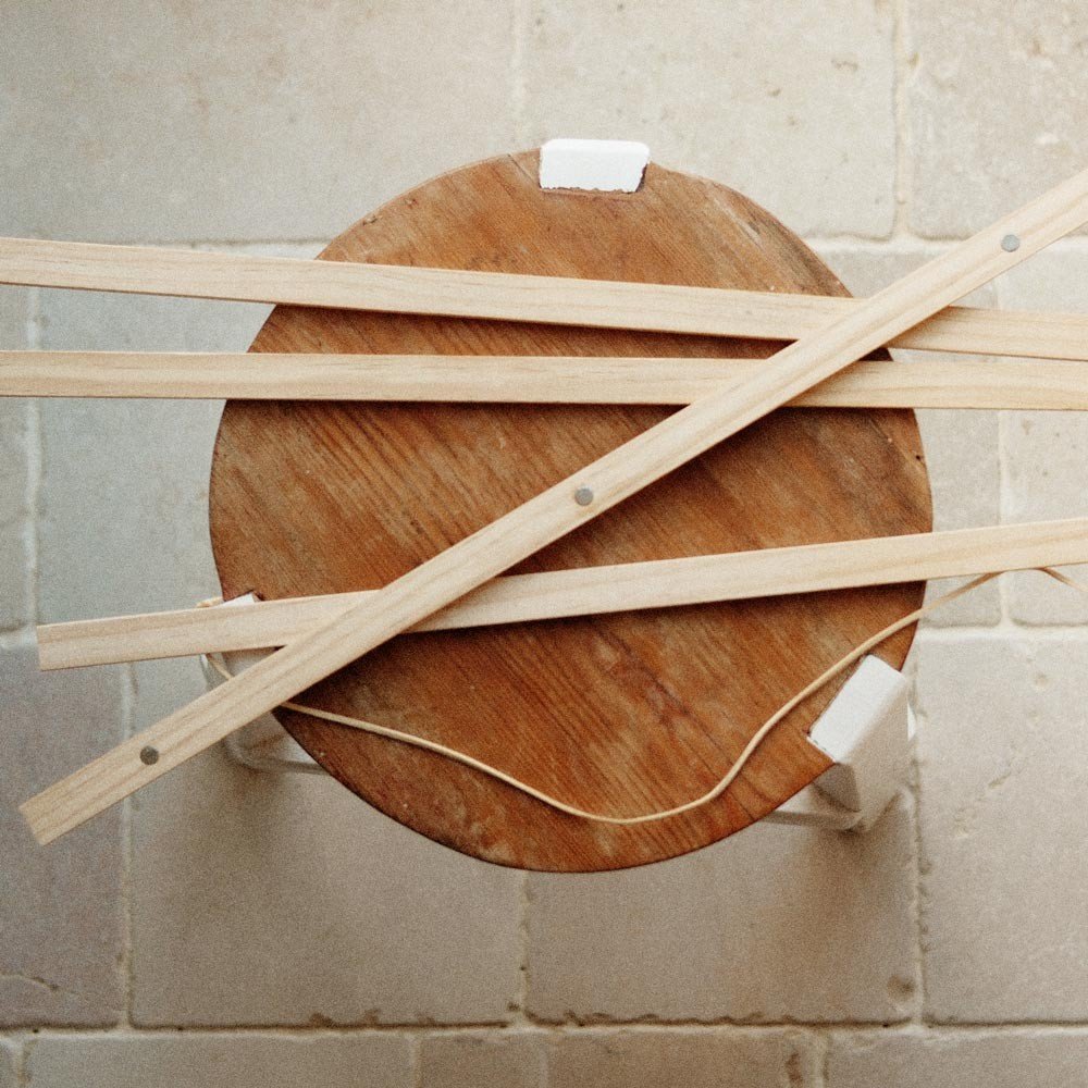 1. Pine wood magnetic frame pieces laid on a round wooden stool, showcasing natural finish and minimalist design