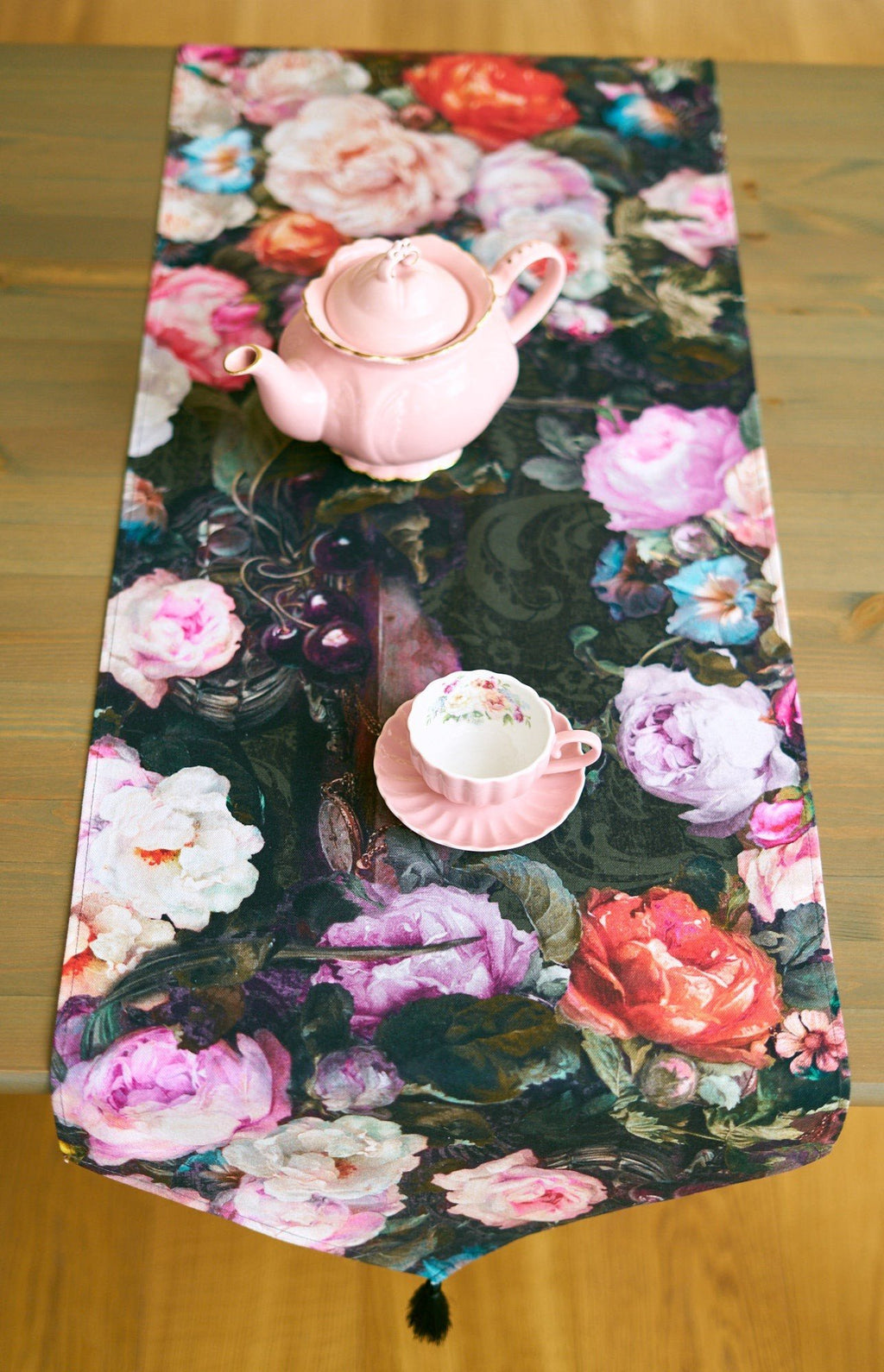 4. Francine black table runner with floral pattern and tassels, pink teapot and cup on wooden table