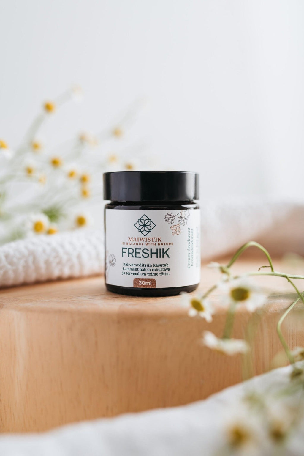 2. MaiWistik FRESHIK Chamomile Cream Deodorant 30ml jar on wooden surface with chamomile flowers, highlighting natural ingredients