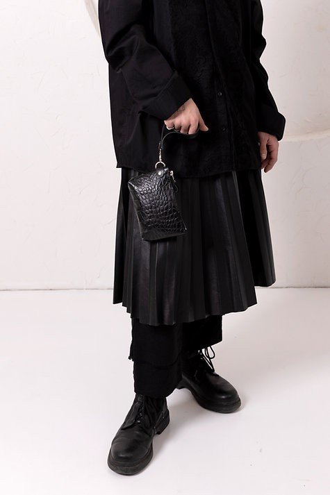 5. Person wearing black skirt and boots holding black alligator leather POUCH wallet by wrist strap