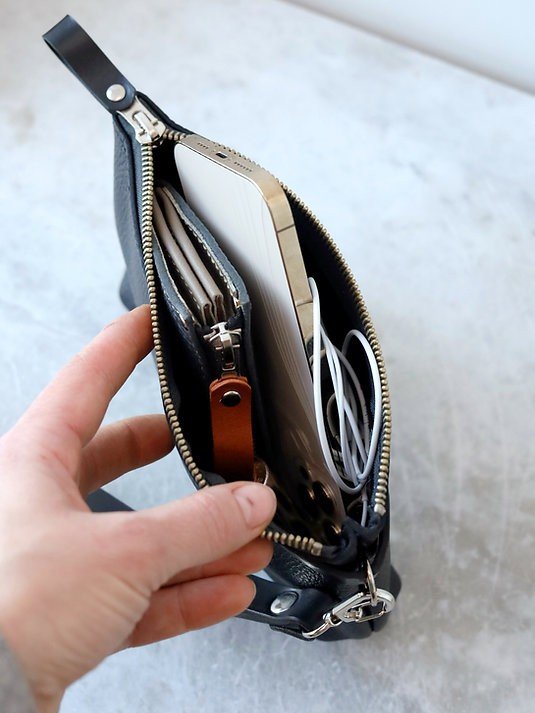 2. Open black alligator leather POUCH wallet showing phone, cards, and earphones inside