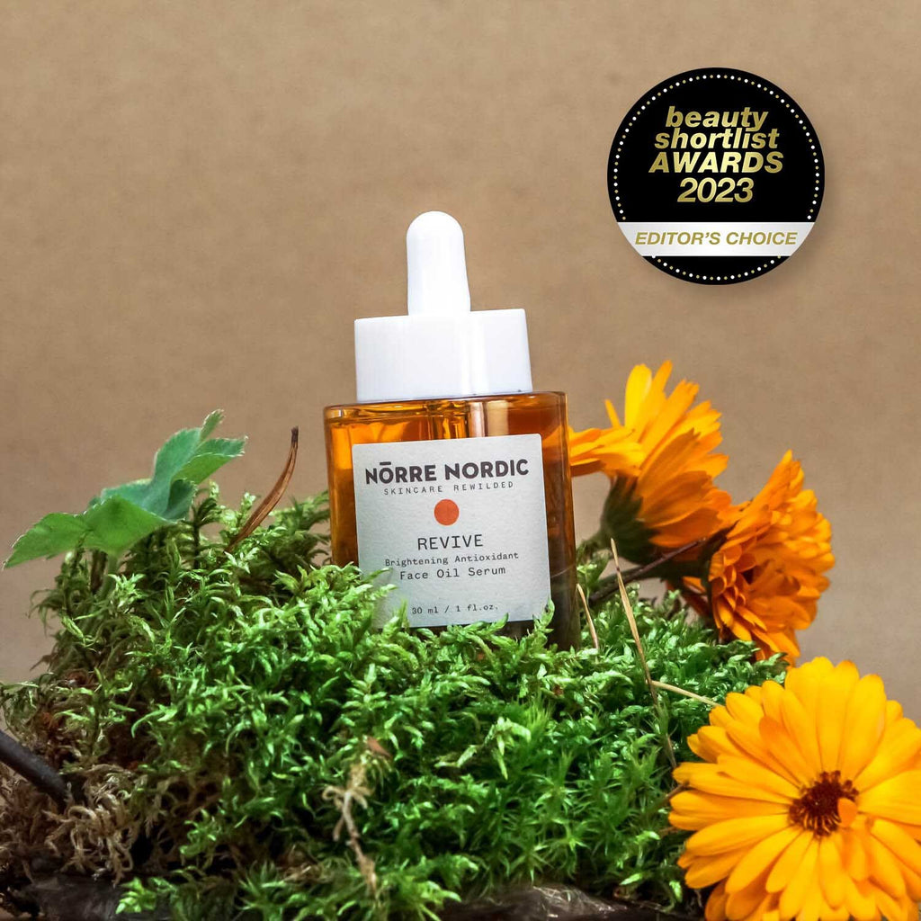 1. Nörre Nordic REVIVE Brightening Antioxidant Face Oil Serum with award badge, surrounded by greenery and flowers