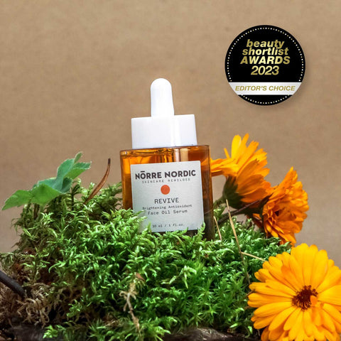1. Nörre Nordic REVIVE Brightening Antioxidant Face Oil Serum with award badge, surrounded by greenery and flowers