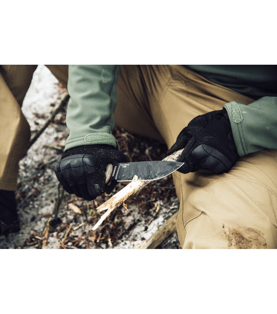 1. Person wearing black Mechanix M-Pact 3 gloves carving wood with a knife outdoors
