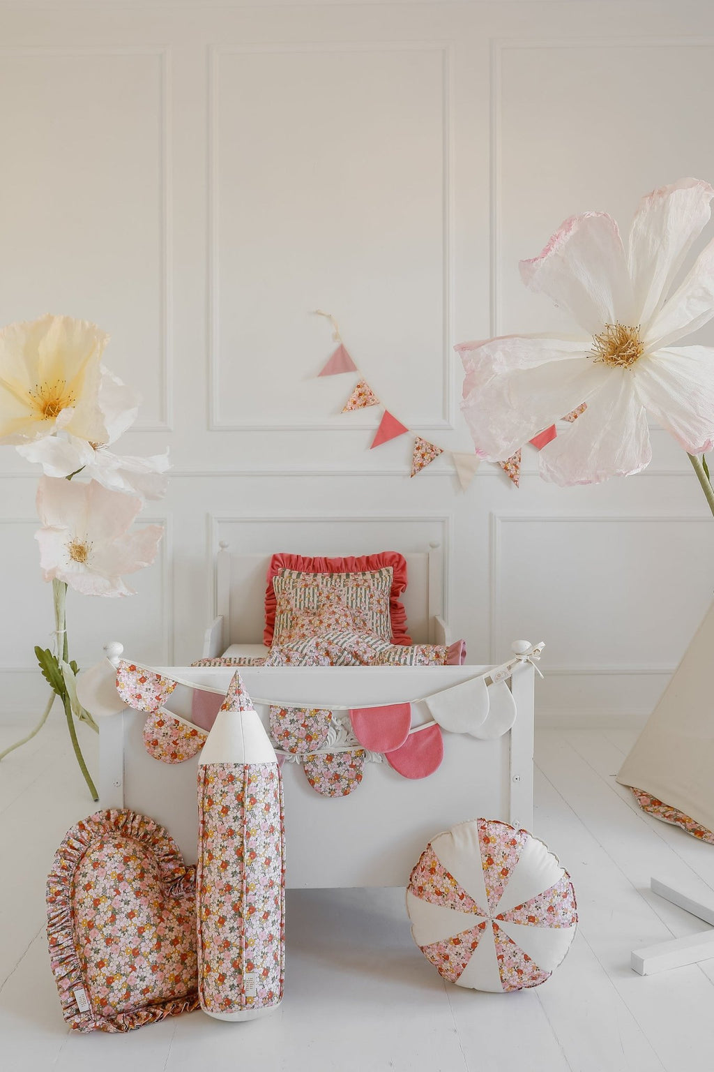 2. Child's room with floral and pink garland, large paper flowers, and matching bedding