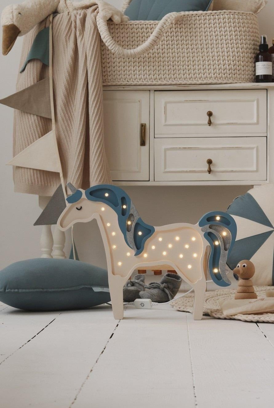 1. Nursery with horse light, pillows, and cream, grey, and teal garland draped on wall