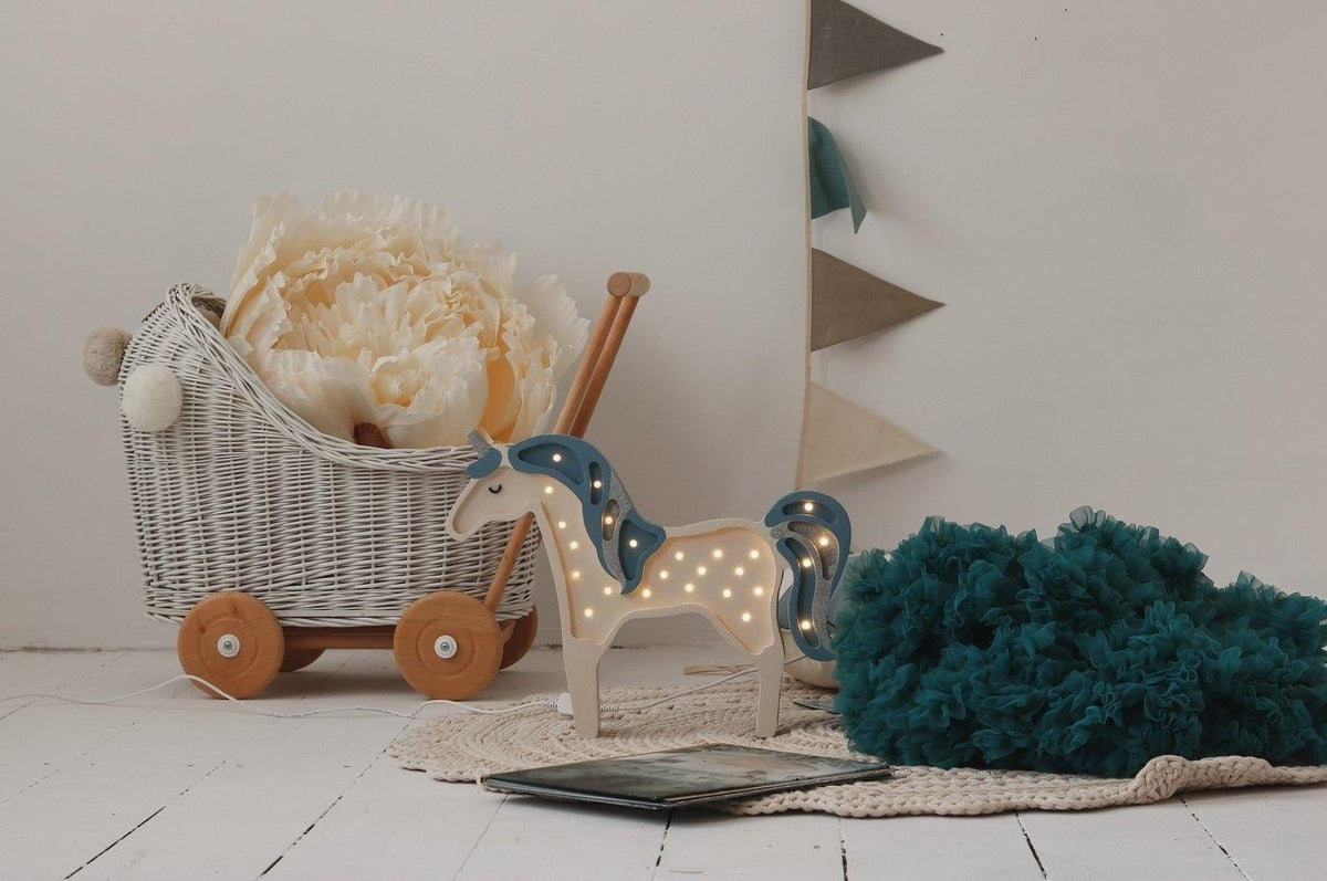 1. Children's room with wicker cart, teal pom-pom, and cream, grey, and teal garland on wall