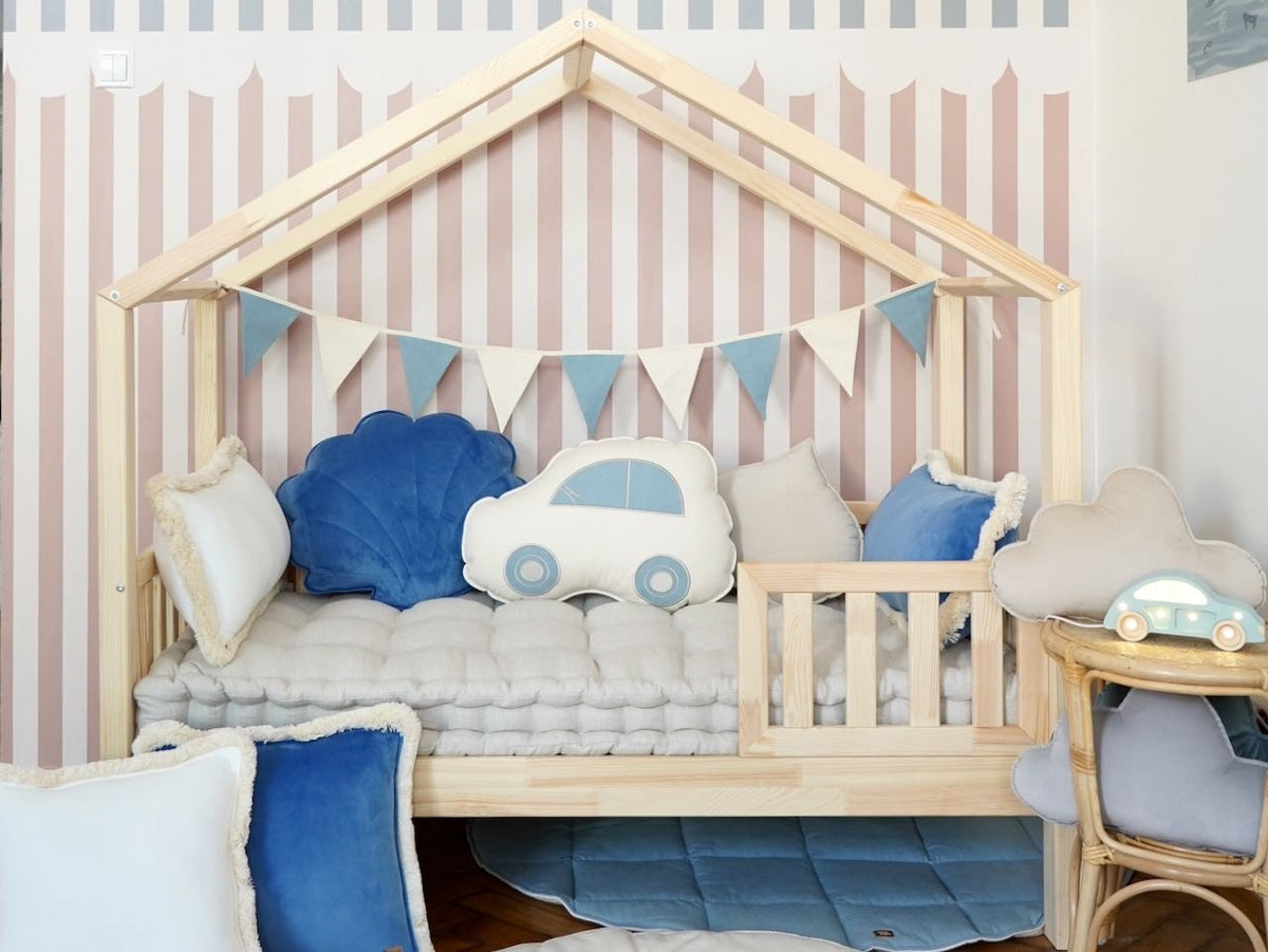 10. Child's room with wooden bed, blue and white garland, and car-shaped cushion