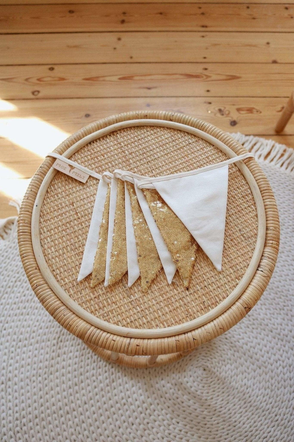 3. Close-up of gold and beige sequin garland on woven wicker surface