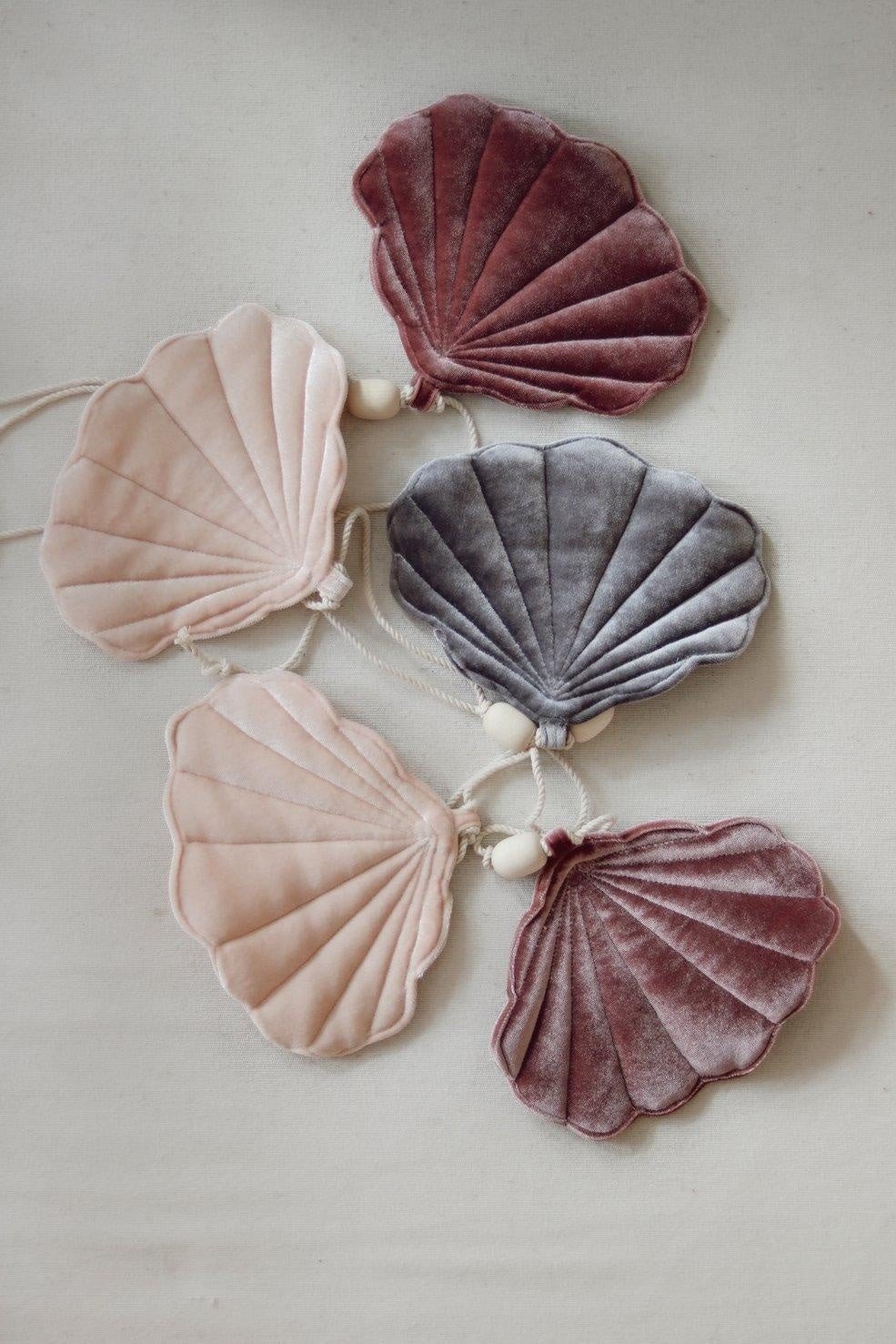 5. Flat lay of velvet shell garland in marsala, pastel apricot, and grey on a neutral background