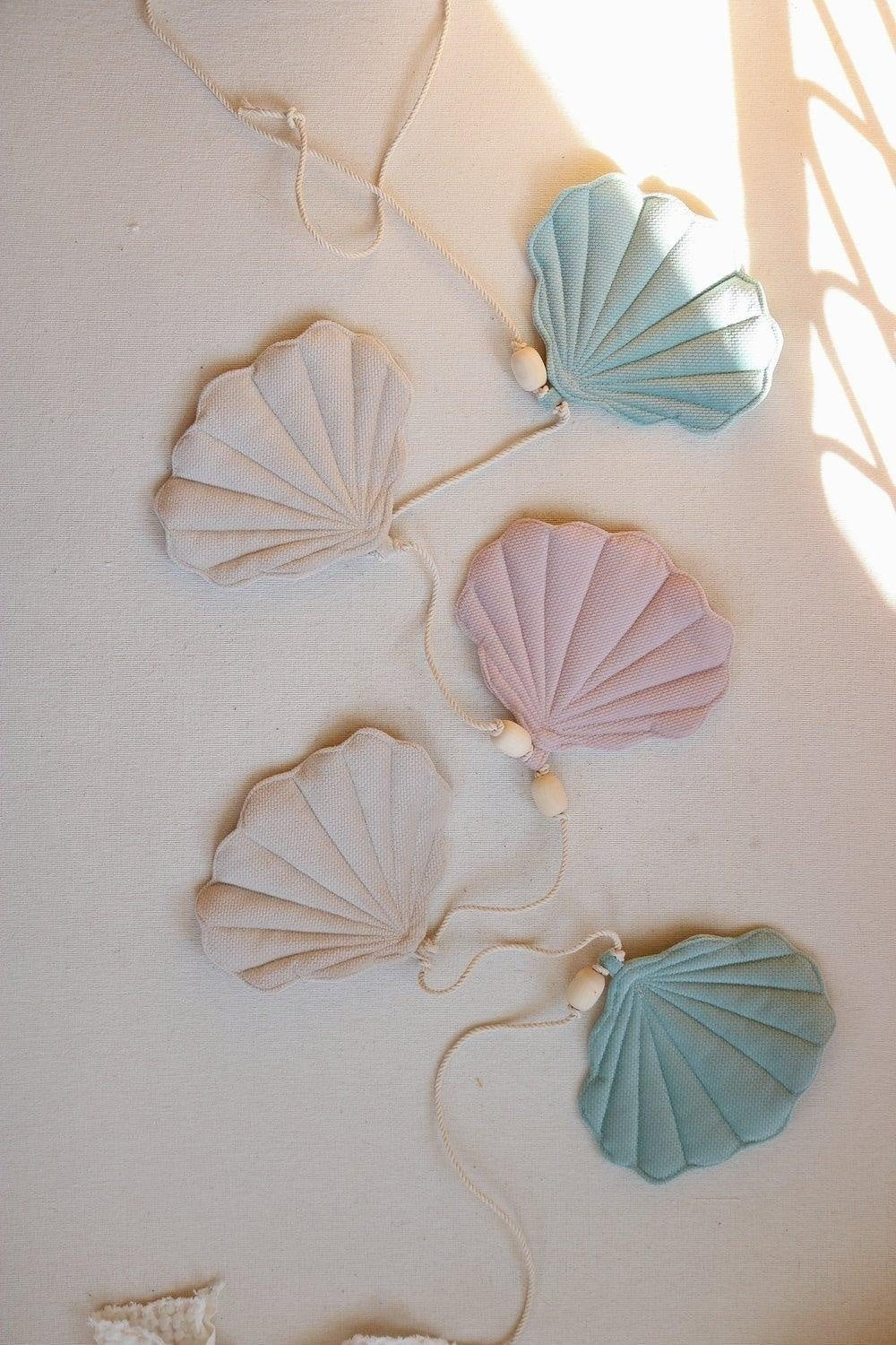 3. Close-up of pastel velvet shell pendants on a cotton string with wooden beads, laid on a light surface