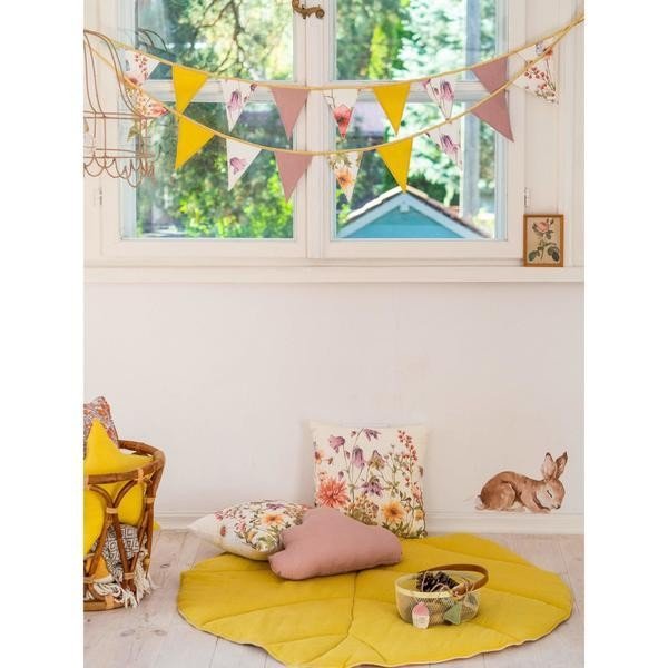 1. Room with floral and solid color garland hanging above a play area with cushions and a toy basket