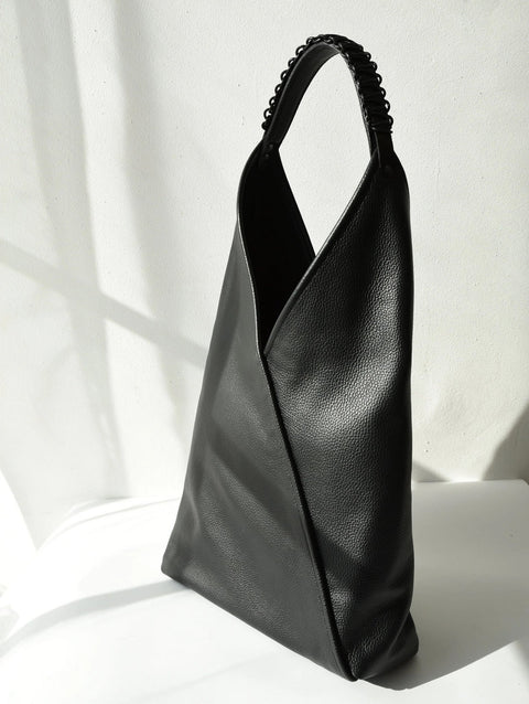 1. Black leather tote bag Ateena by Gerda Retter Design, showcasing Nordic simplicity and geometric elegance in a studio setting